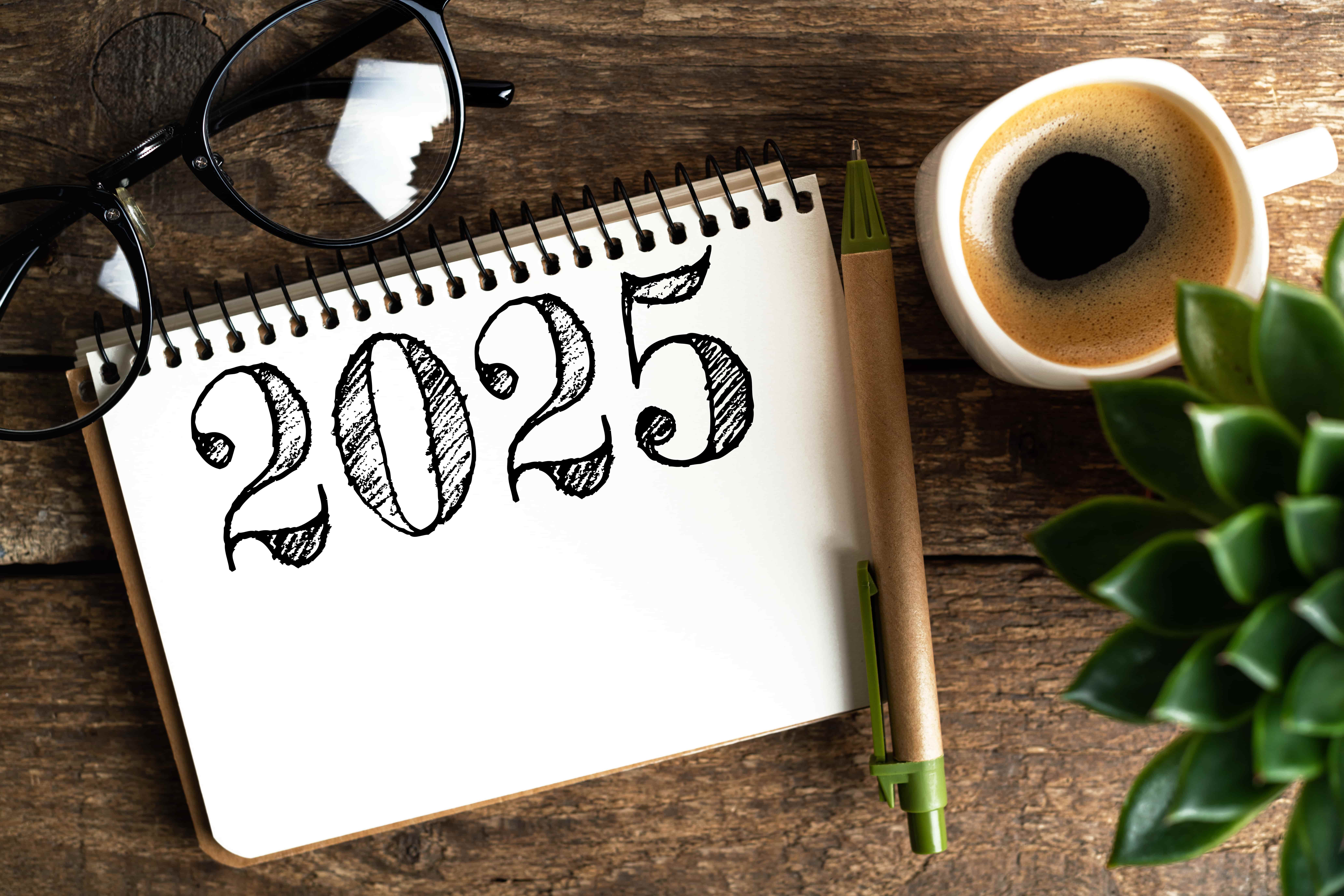 Bloc notes avec l'inscription 2025 entouré d'objets