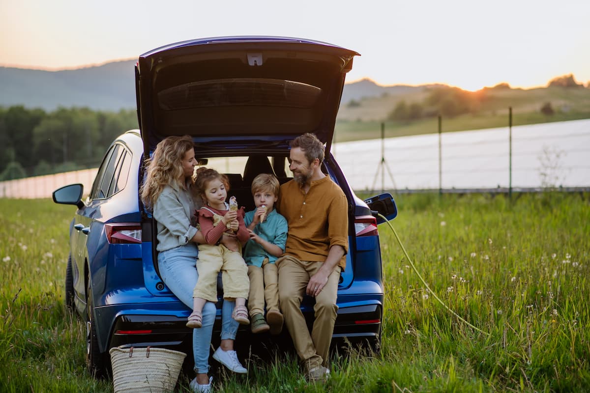 famille assise sur une voiture electrique