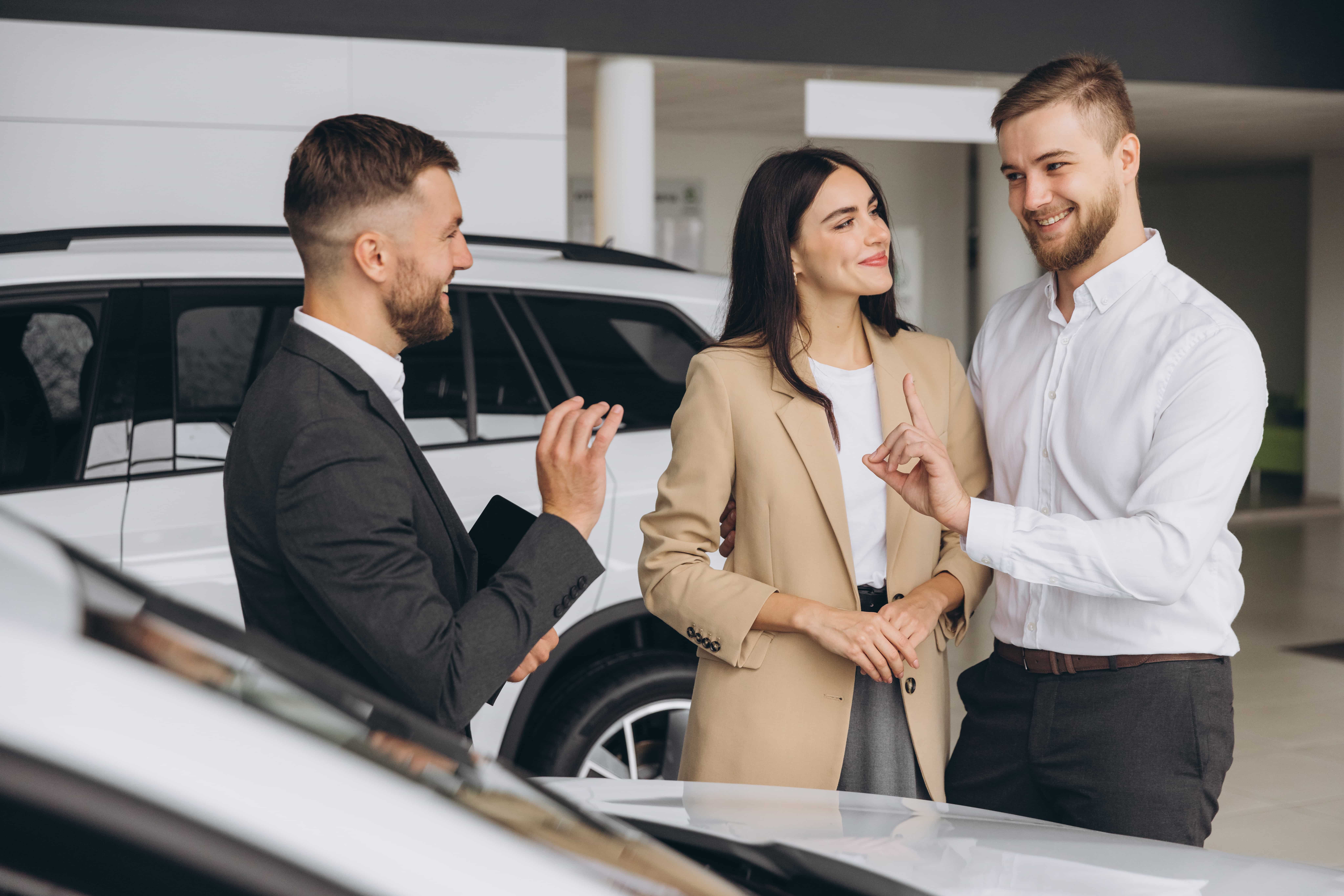 couple echange avec un conseiller commercial dans une concession automobile