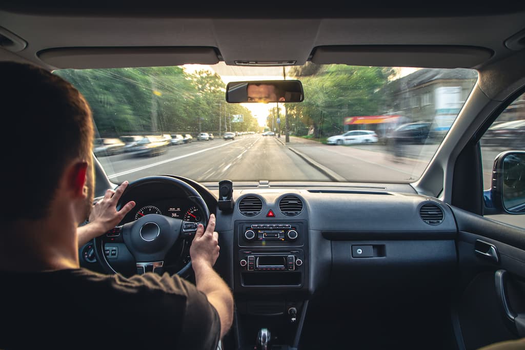 mains-sur-le-volant-lors-de-la-conduite-a-grande-vitesse-depuis-l-interieur-de-la-voiture